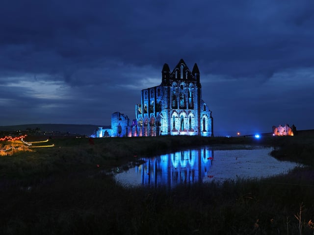 Whitby Abbey bathed in blue light.