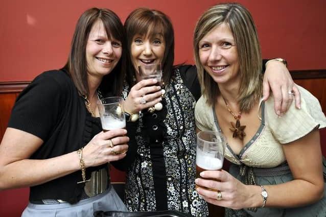 Three friends catch up over a drink.