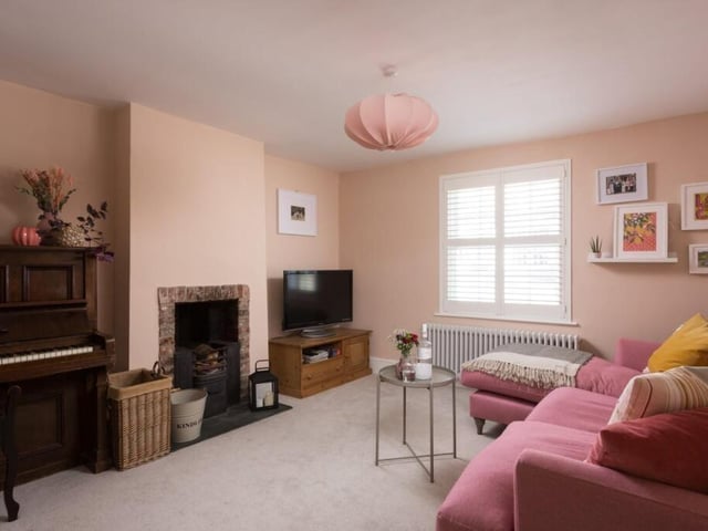 A second reception room with wrought iron fireplace.