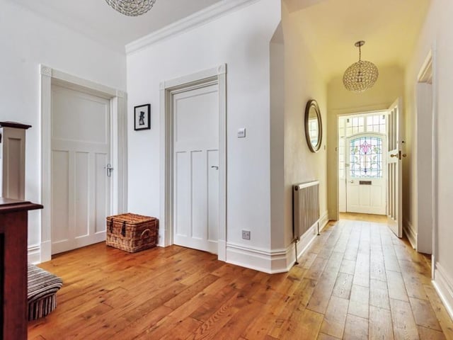 A front door with stained glass feature leads in to a vestibule and a roomy hallway.