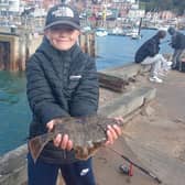 Teddy Stringer, 11, who won the Knight Trophy for the Greatest Variety of Fish Species (5), shows off a flounder at the Junior Parr Competition on Saturday, the second event of the Scarborough Angling Festival.