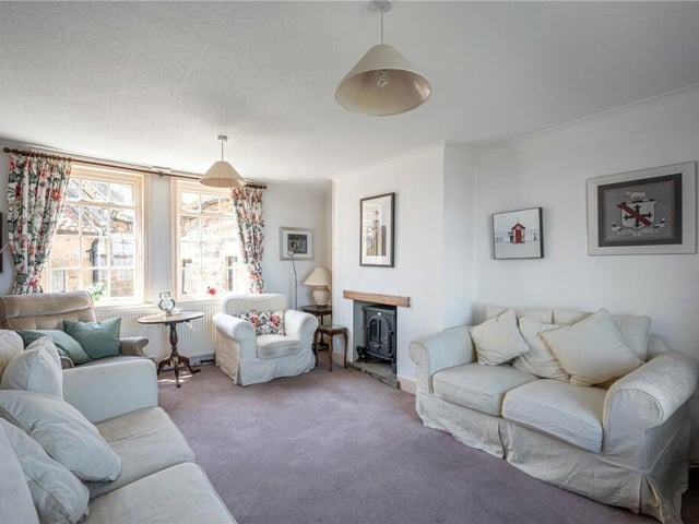 A bright sitting room, with feature fireplace.