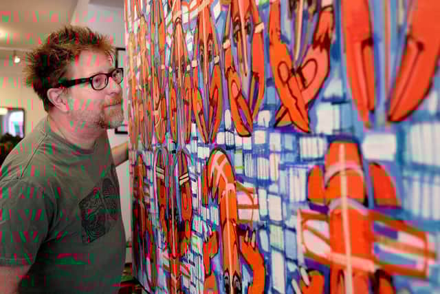 Sean views one of the artworks on display.