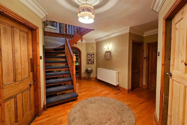 A spacious hallway, with staircase up, leads to various rooms within the property.