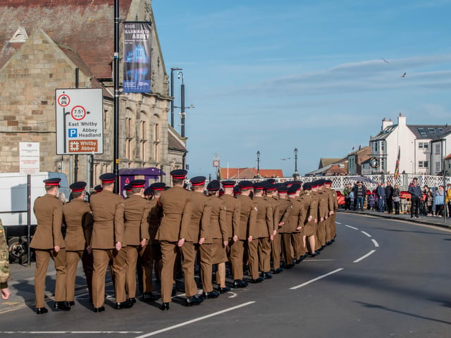 The parade through town is watched by a crowd of onlookers. Photo: Deborah McCarthy