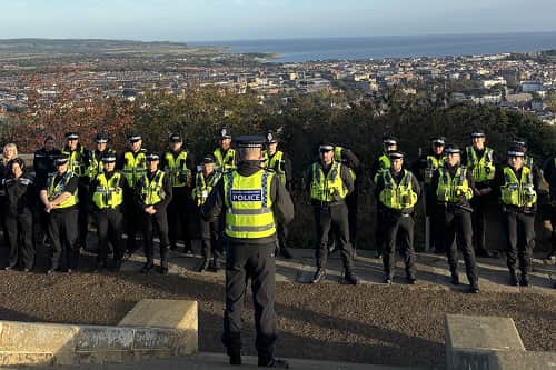 Officers receive their briefing at Oliver's Mount before deploying to execute early-morning warrants as part of Operation Tornado.