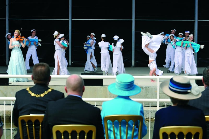 Scarborough's talented youngsters perform for the Queen (blue hat) with violinist Victoria Yellop.
102087m