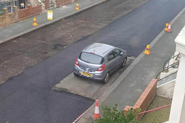 The road remains unsurfaced beneath the car