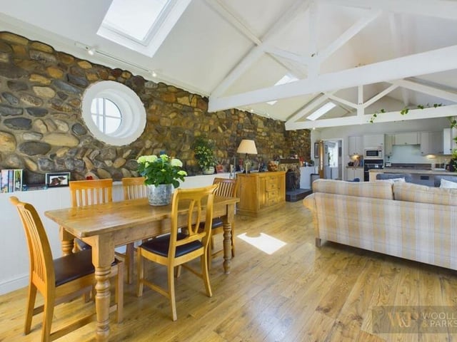 A cobblestone wall is a feature in the living and dining area.