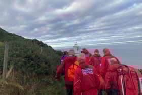 Mountain recue team members carry the casualty to a waiting vehicle