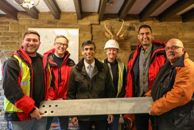 Adam Ramsden, safety adviser, David John, director of sites, Prime Minister Rishi Sunak, Penny Holland, project manager, Shuja Khan, chief executive at Arqiva, Billy Wilkinson, rigger with a piece of steel signed by Mr Sunak to be used in the mast construction.