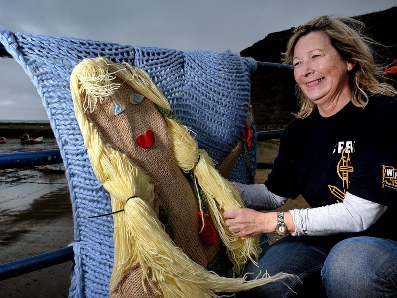 Jacqueline Power arranges the knitted mermaid on the seafront.
picture: Richard Ponter