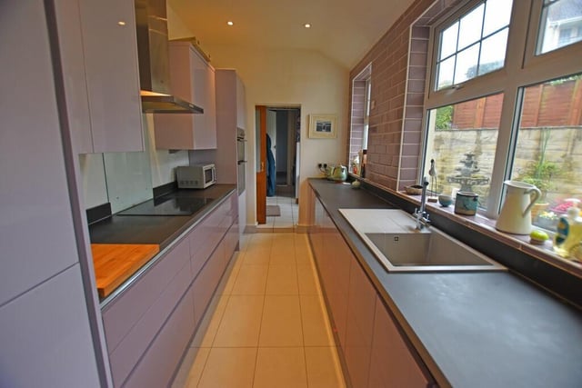 The light and modern kitchen has two sets of windows, and fitted units with integrated appliances.