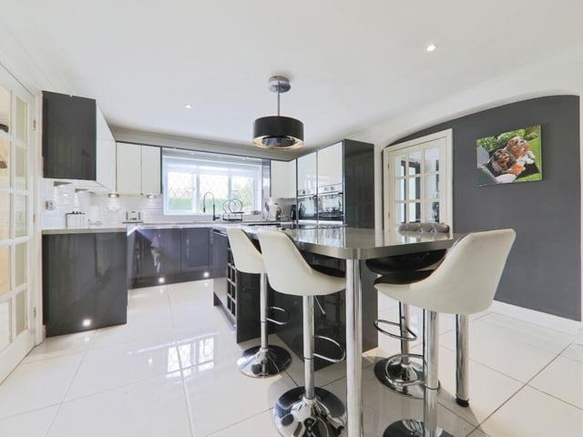 The sleek fitted kitchen with central island and breakfast bar.