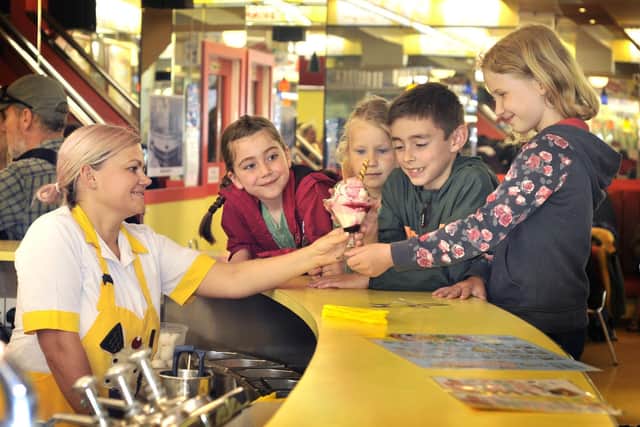 Dace Timmins serves ice cream to a group of excited children at Scarborough's Harbour Bar.