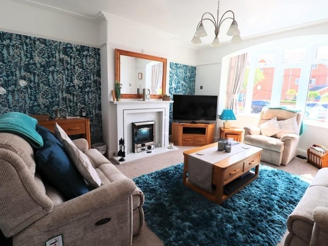 A large fireplace and a bay window are features within this lounge.