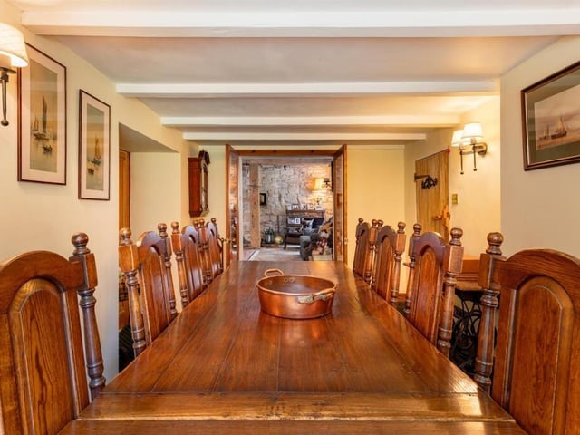 A beamed, formal dining room has space for a larger style suite.