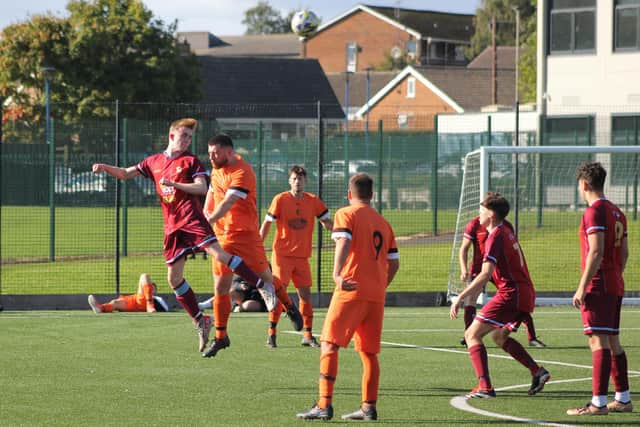 Edgehill's Joe Gallagher is beaten in the air during their 7-1 Senior Cup win.