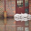 Sandbags outside front door of flooded house. Photo: Adobe