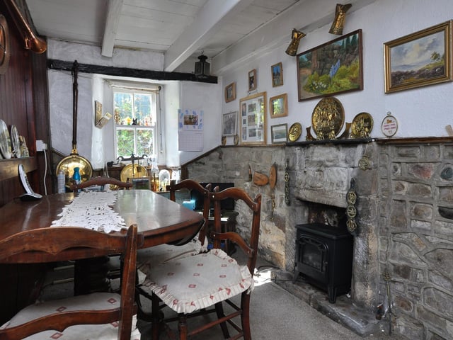 This versatile room has a stone fireplace and wall panelling.