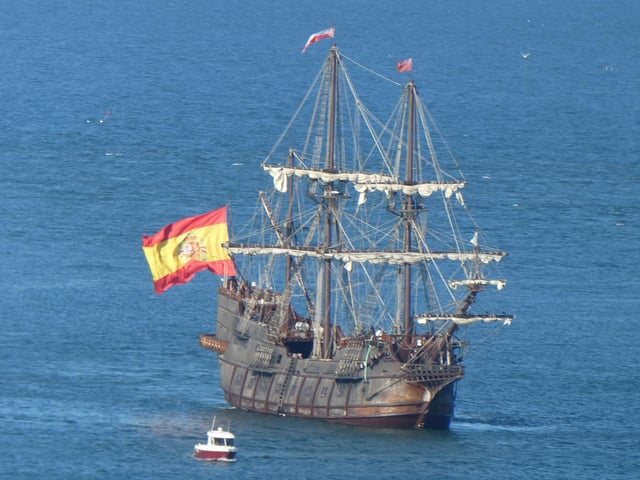 The galleon dwarfs a smaller boat.
