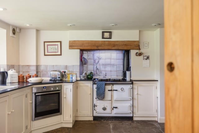 The country style kitchen has fitted units and a range style oven.