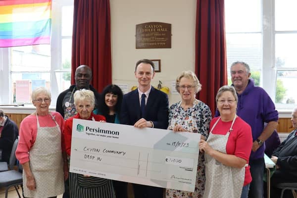 Volunteers of the Cayton Community Drop in receive cheque from Persimmon