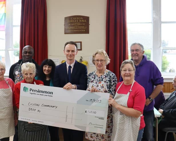 Volunteers of the Cayton Community Drop in receive cheque from Persimmon