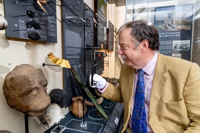 North Yorkshire Council’s executive member for arts and culture, Cllr Simon Myers, looks at the gold lunula in its display case at the Craven Museum.