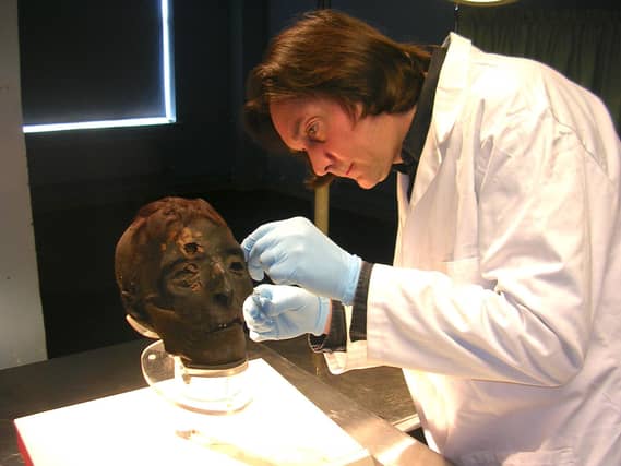 Dr Stephen Buckley examining a mummified skull