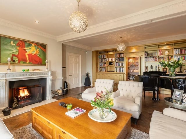 The drawing room has an historic fireplace and bespoke wall to wall cabinetry with a concealed bar.
