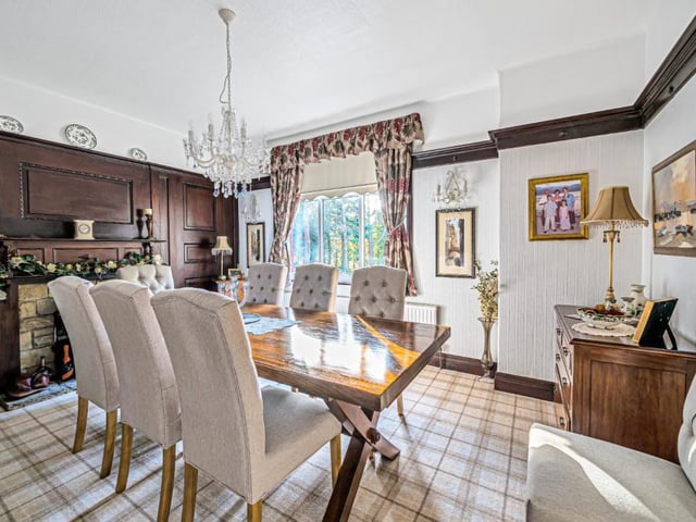 The dining room is of a good size, with a wood panelled wall and fireplace.