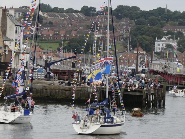 Commodore's boat, moored on the left, is saluted by one of the boats in the regatta sail past.
