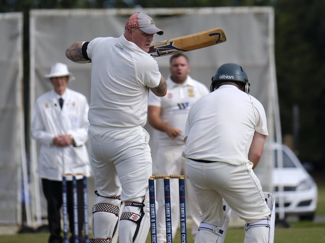 Darrol Lewis, Seamer, looks back anxiously as Flixton 2nds keeper Will Norman collects the ball