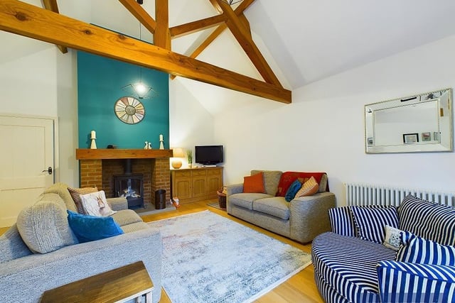 An alternative view of the spacious lounge, with feature fireplace and log burning stove.