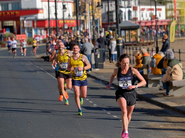 The Scarborough 10k ladies winner Claire Cooney checking her watch, followed by Bridlington Road Runners Dan Cawthorn and NIck Jordan. Photo by Richard Ponter
