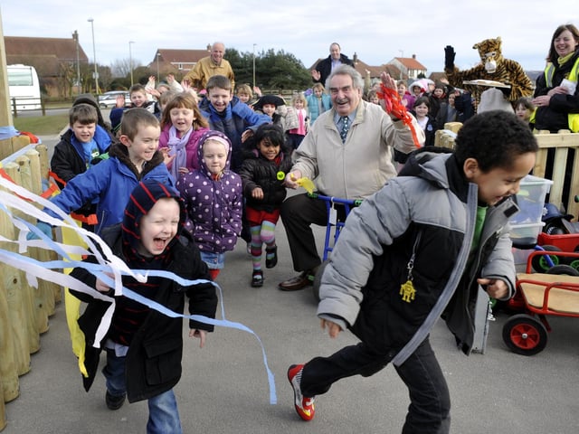 Chairman of governors Tom Swift, right, cuts the ribbon on the new play area at Wheatcroft Primary School letting the Reception and Year 1 children rush in.