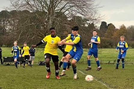 Scalby U14s' Dinga Sthandiwe, yellow shirt, challenging for ball.