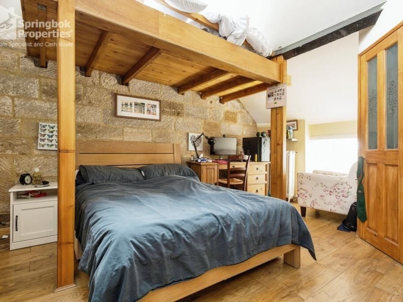 A character room with an exposed stone wall feature.