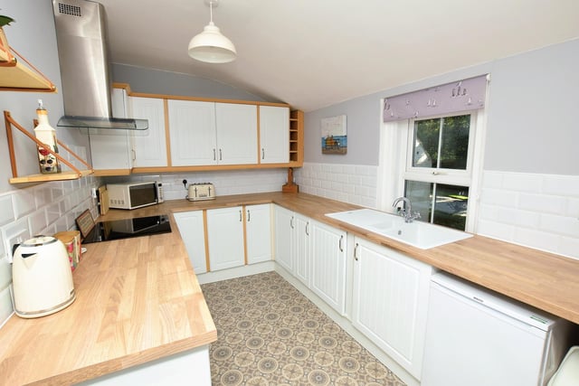The modern kitchen has fitted units and appliances.