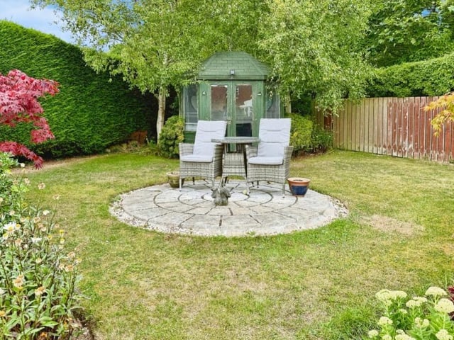 The garden includes a summer house in one corner.