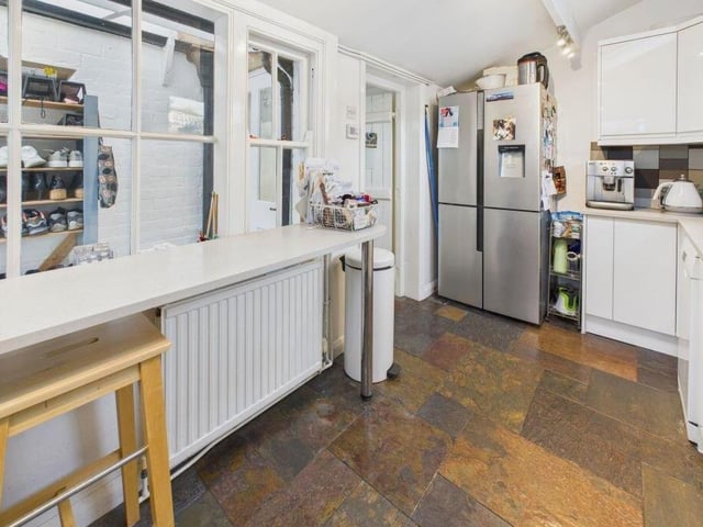 The kitchen has fitted units with integrated appliances, and a breakfast bar.