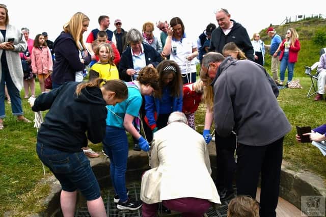 Time capsule being lowered into the well at Sandal Castle