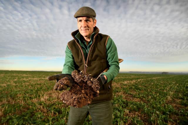 Paul Temple tests the earth on his farm.