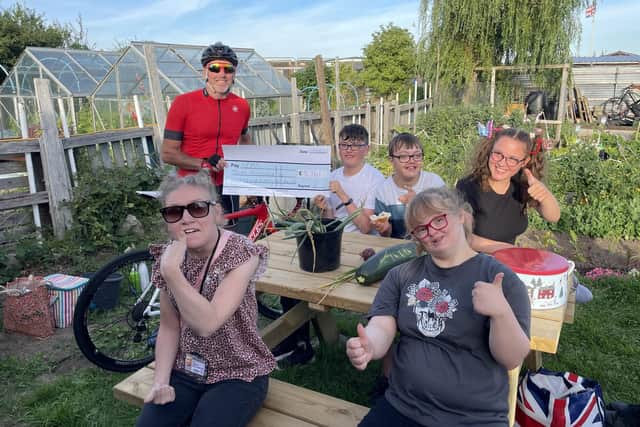 Robert Wilson presents his cheque to youngsters at Gems.
