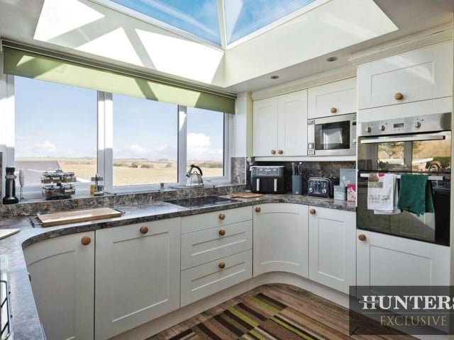 The modern kitchen has a lantern style roof admitting plenty of natural light.