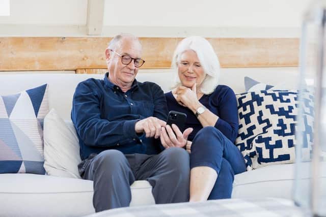 Married couple on a sofa looking at a smart phone