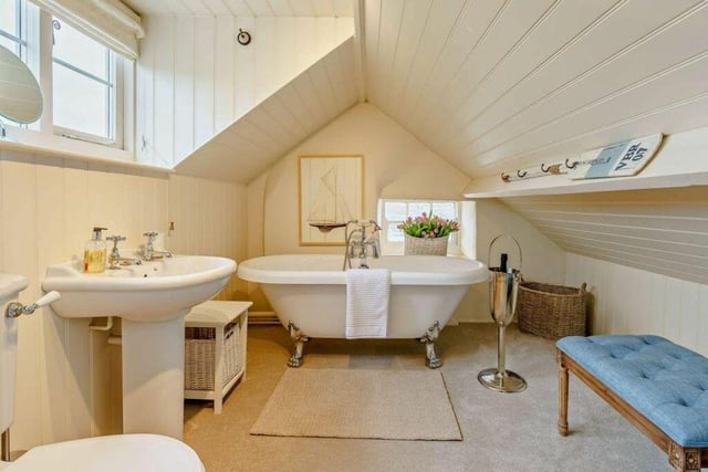 A charming bathroom featuring a free-standing, roll-top bath.