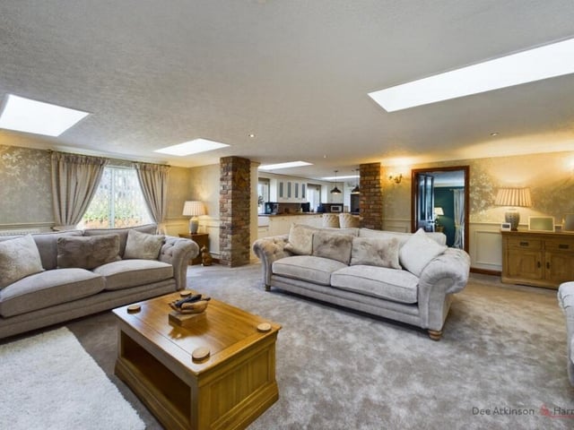 The living room, with kitchen to the rear, has a large log burner.