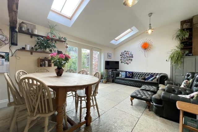 Dining and relaxed seating areas with the cottage's beamed open plan living kitchen.